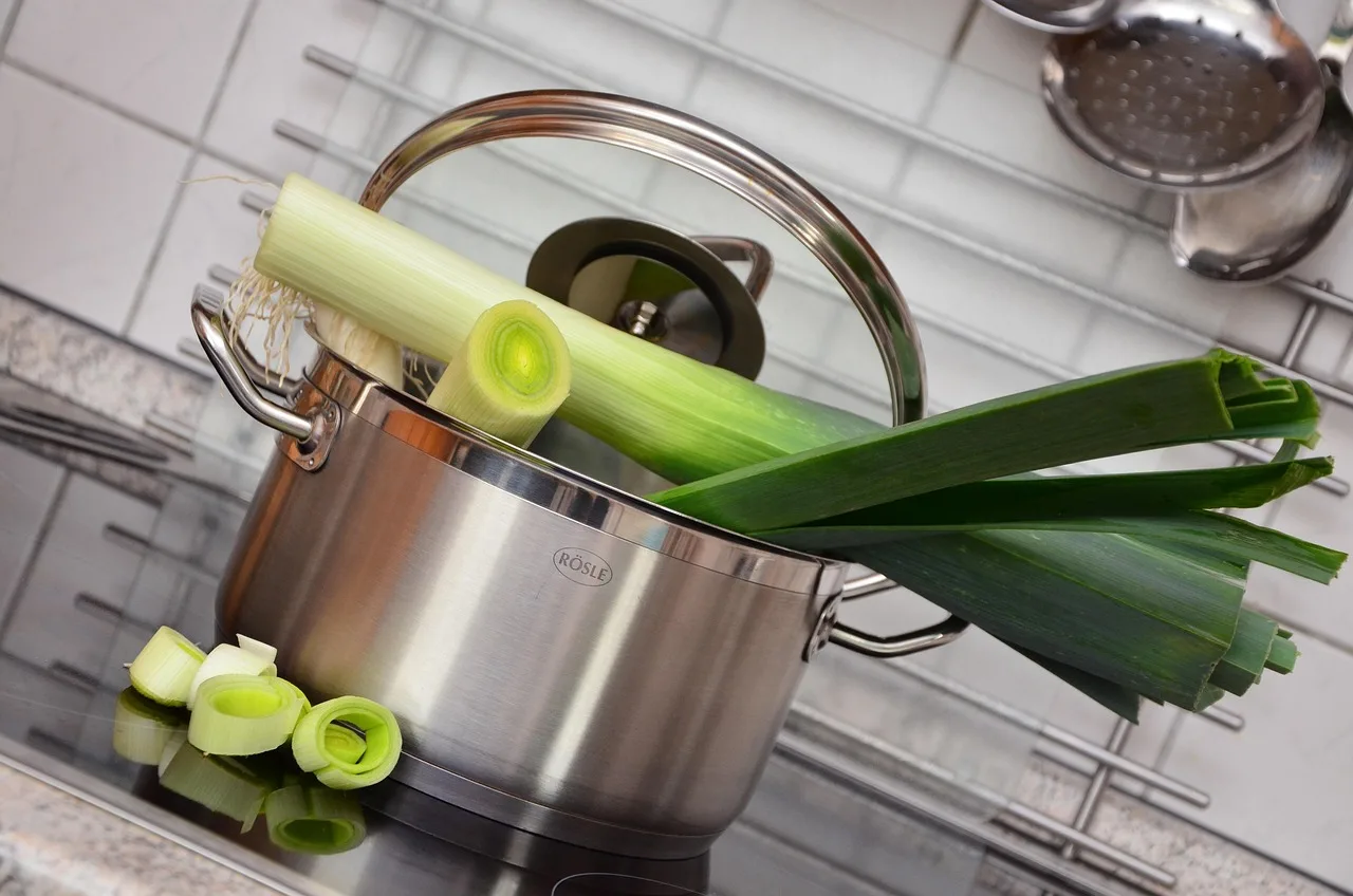 Pot and pan organizer in a kitchen cabinet with stacked cookware and a tape measure
