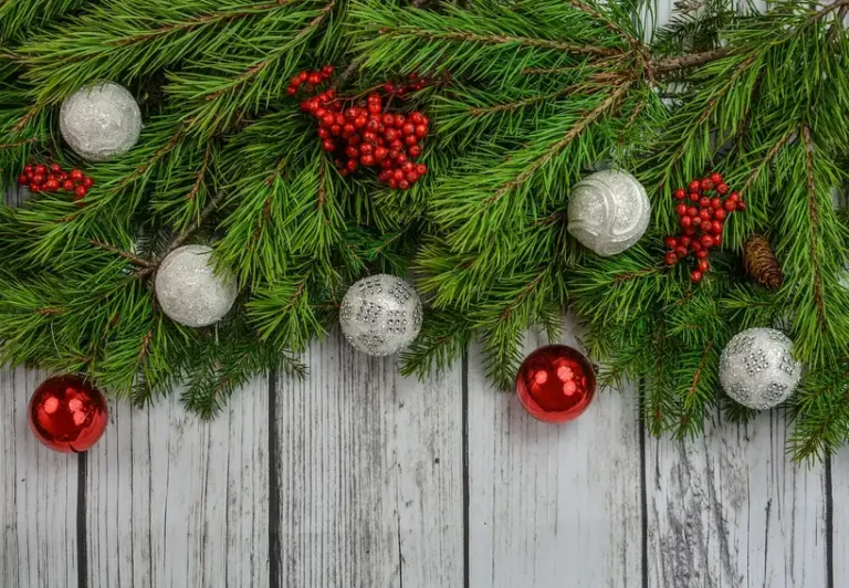 Christmas garland wrapped around a curved wooden staircase banister in natural light