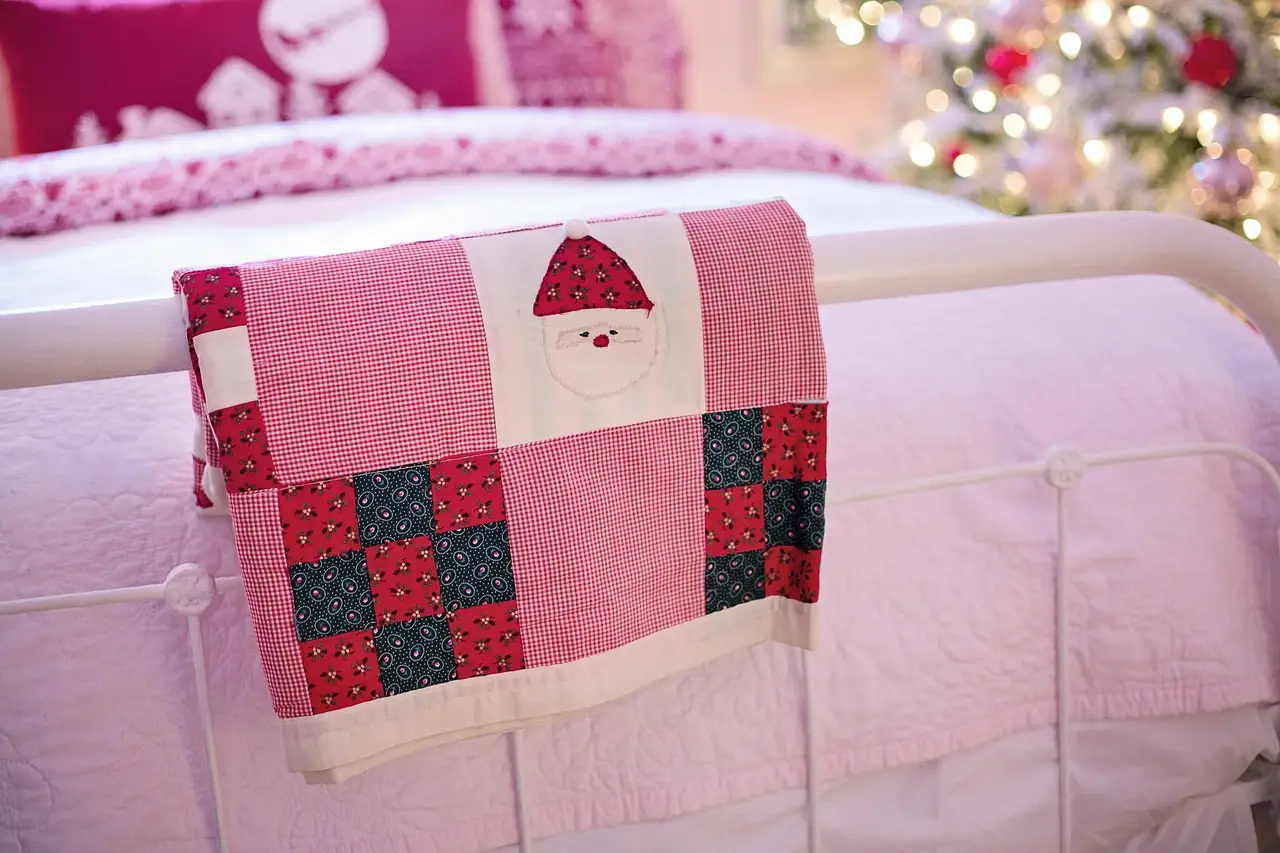 A cozy winter bedroom with layered bedding, a knit throw, and warm natural light.