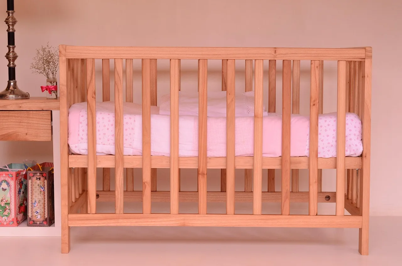 Person inspecting broken bed slats under a mattress on a platform bed