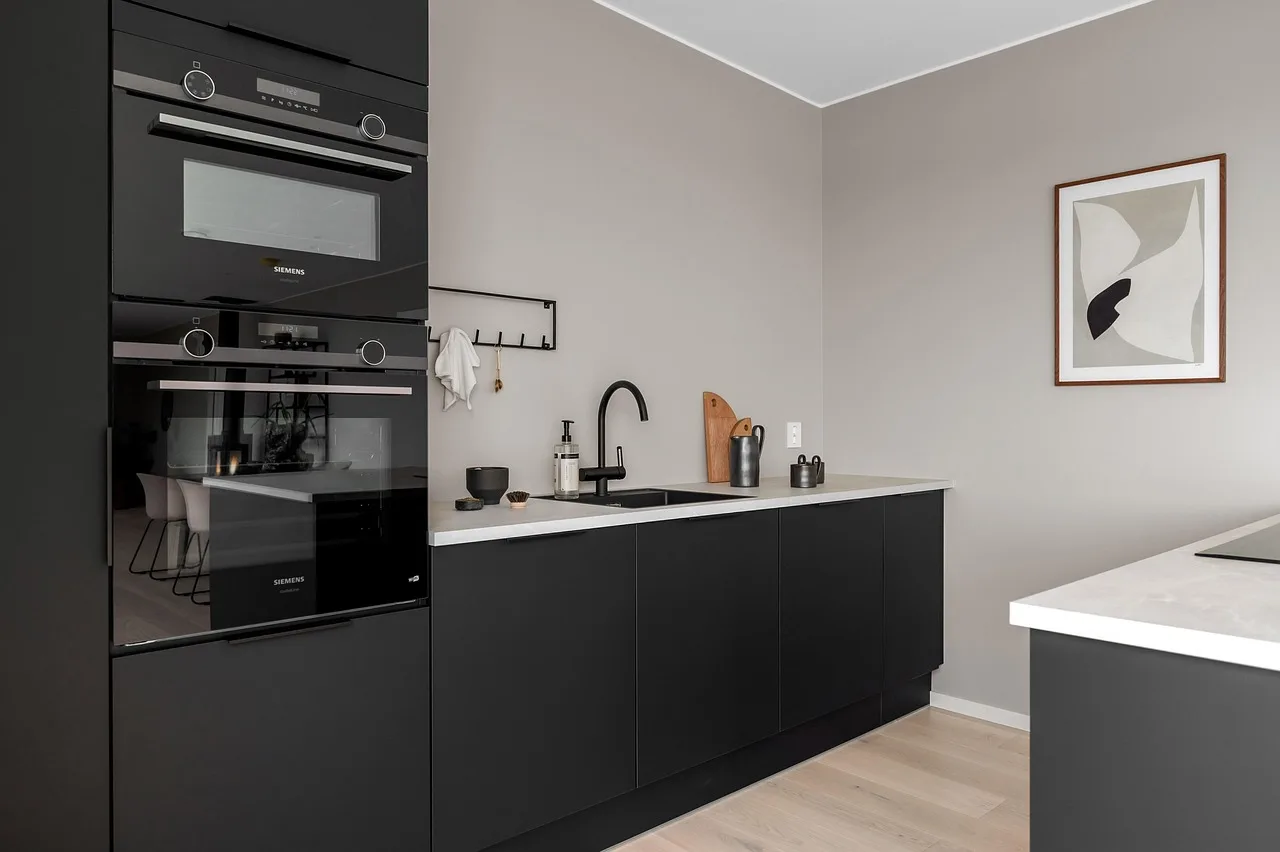 Homeowner and designer reviewing a kitchen cabinet quote beside cabinet samples and a calculator