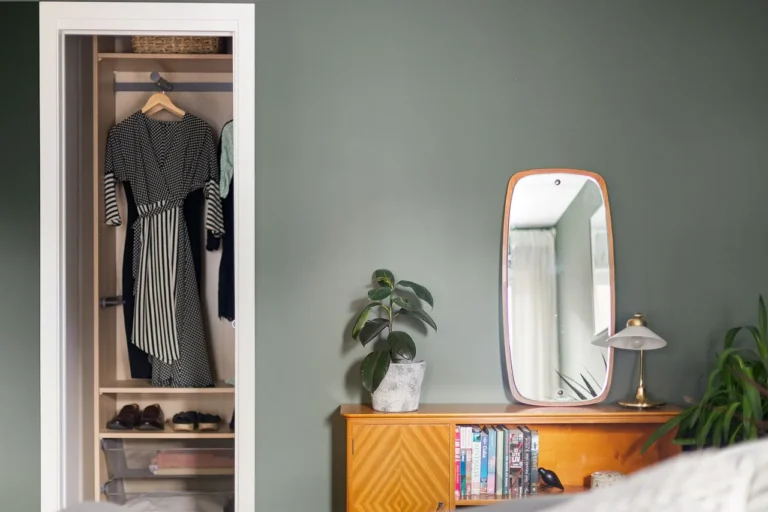 Mainstays dresser in a bright bedroom with a lamp, folded clothes, and a plant