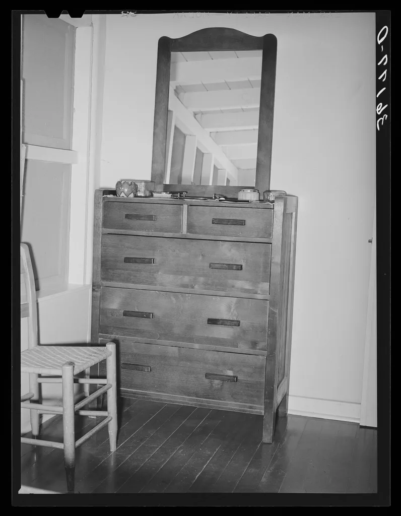 Close-up of a wall anchor being tightened behind a Prepac dresser