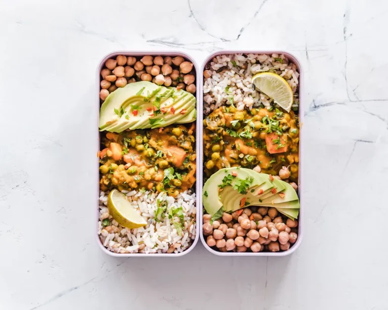 Ramadan meal prep containers arranged on a kitchen table with prepared iftar and suhoor foods