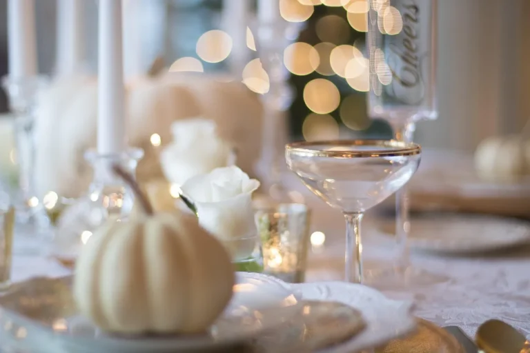Romantic dinner tableware set on a candlelit table with plates, flatware, wine glasses, and pasta