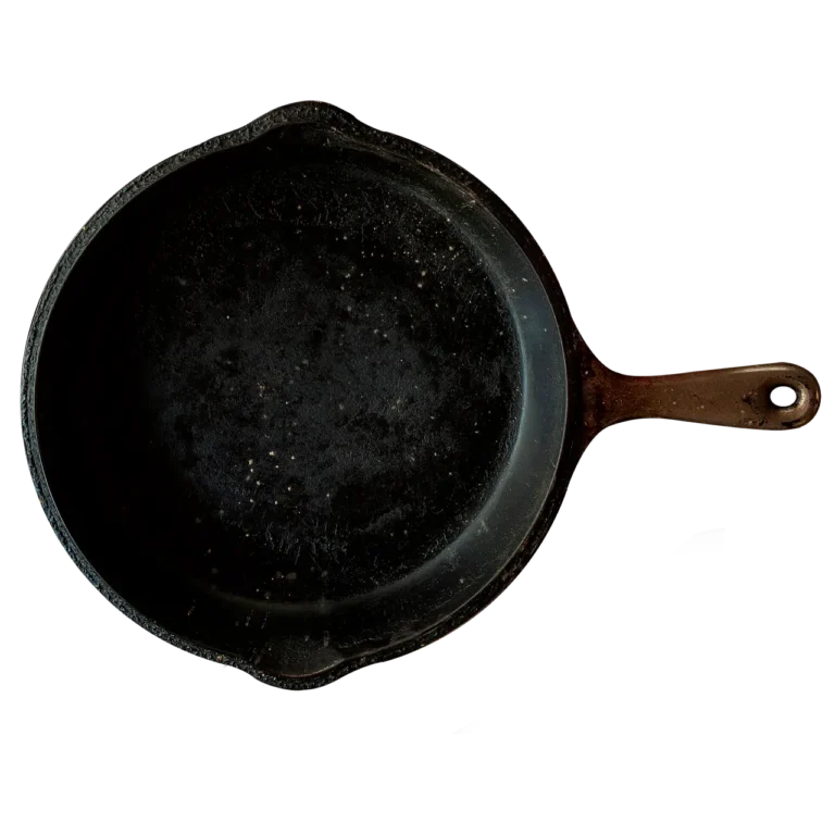 Cast iron skillet and stainless frying pan side by side on a sunlit counter