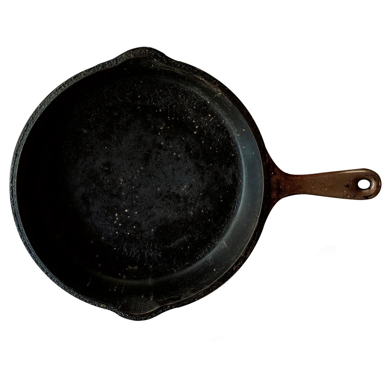 Cast iron skillet and stainless frying pan side by side on a sunlit counter