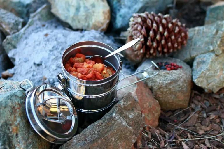 Stainless steel cookware set on a kitchen counter beside a home cook's hands