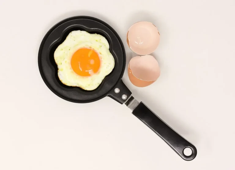 T-fal nonstick cookware on a kitchen counter with a used skillet, eggs, and a spatula in natural light