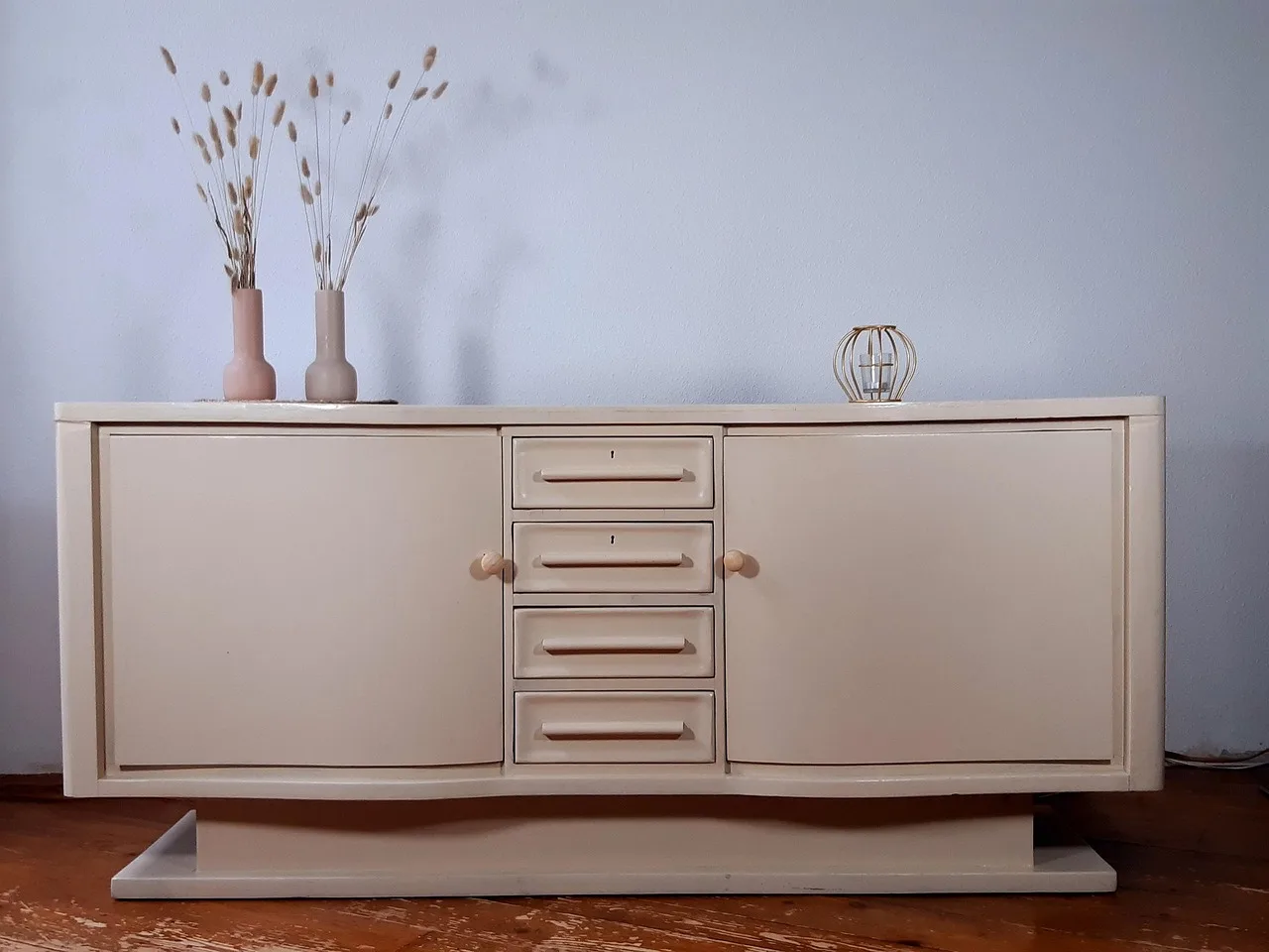 A Wayfair dresser in a sunlit bedroom with one drawer open and folded clothes inside