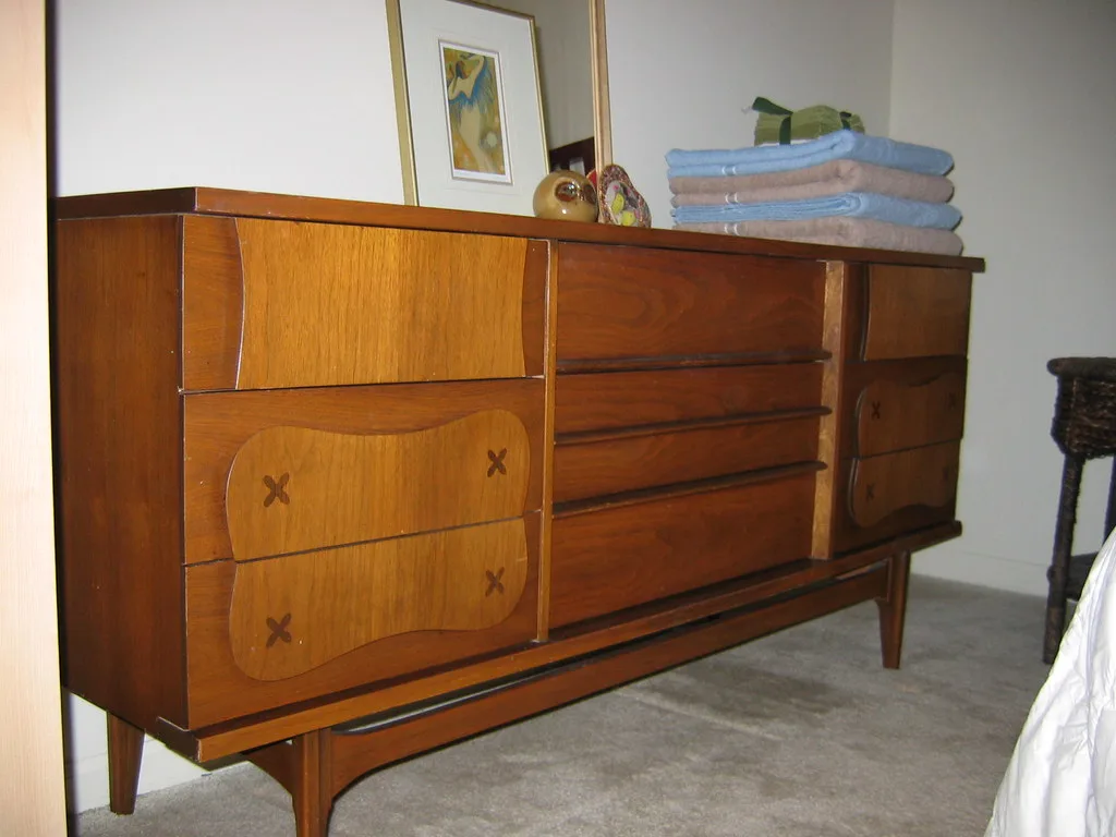 Close-up of a tall dresser drawer with a hand reaching it beside measuring tools