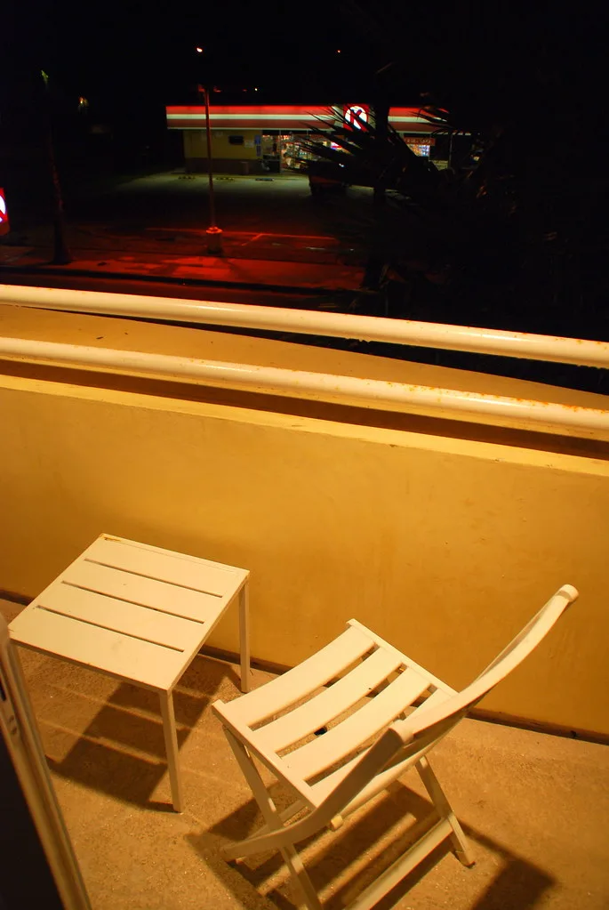 Close-up of wood balcony furniture and metal balcony furniture showing grain, rust, and water droplets